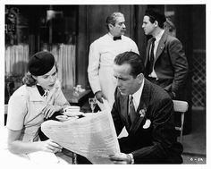 black and white photograph of people sitting at a table with papers in front of them