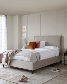 a bedroom with white walls and beige furniture