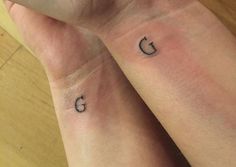 two people with matching tattoos on their wrists, one has the letter g and the other has the word c