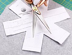 scissors are being used to cut paper into shapes that look like an origami