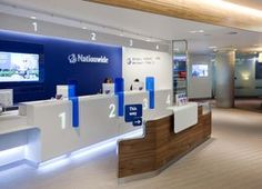 the interior of a store with blue and white counter tops, televisions on the wall