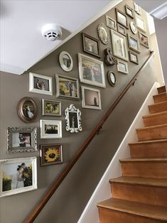 a staircase with pictures on the wall next to it