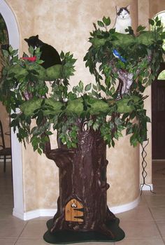 a cat sitting on top of a tree in a living room next to a doorway