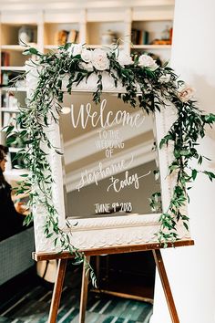 a welcome sign with greenery on it