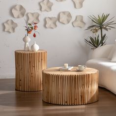 two wooden tables sitting on top of a hard wood floor next to a white couch