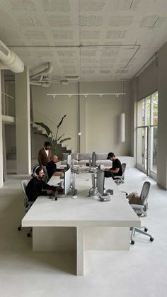 three people sitting at a table in an office