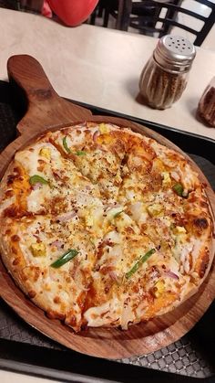 a pizza sitting on top of a wooden cutting board