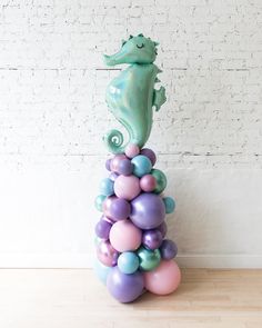 there is a sea horse on top of balloons