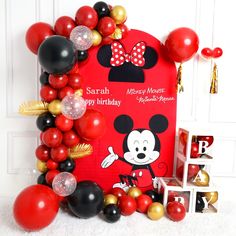 a mickey mouse birthday party with balloons and decorations