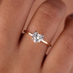 a woman's hand with a diamond ring on her finger, showing the center stone