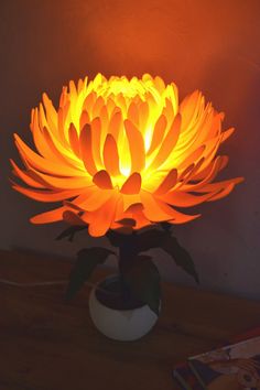 a lit up flower sitting on top of a table