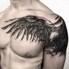 a black and white photo of a man's chest with an eagle tattoo on it