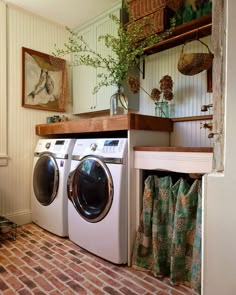 a washer and dryer sitting in a room next to each other on a brick floor