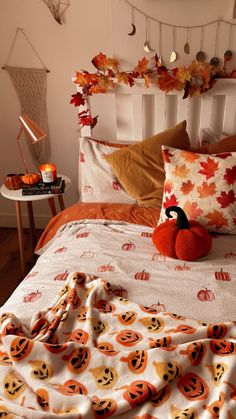 a bed topped with lots of pillows covered in pumpkins