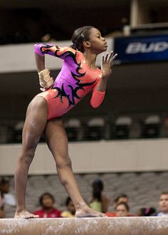 a woman standing on top of a balance beam