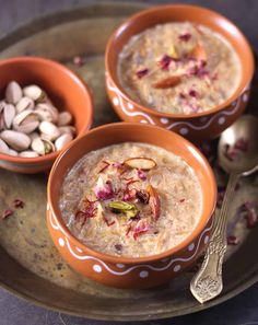 two bowls filled with oatmeal and nuts on top of a metal tray