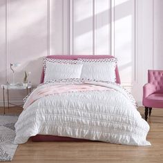 a bedroom with pink walls, white bedding and a pink chair in the corner