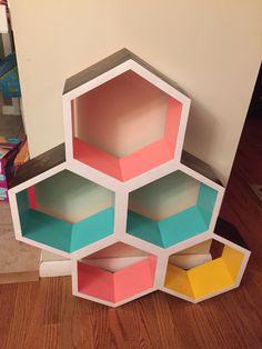 several hexagonal boxes stacked on top of each other in the middle of a room