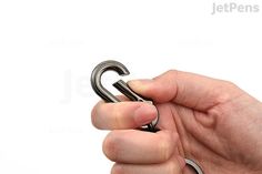 a hand holding a metal object in it's left hand on a white background