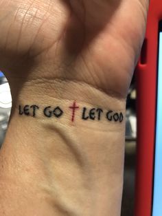 a person with a wrist tattoo that says let go let god