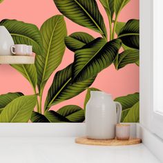 the wallpaper in this kitchen is painted with green leaves and pink background, along with a white vase