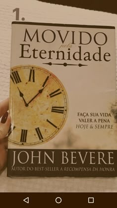 a person holding up a book with a clock on it's cover and the words movido eternidade written in spanish