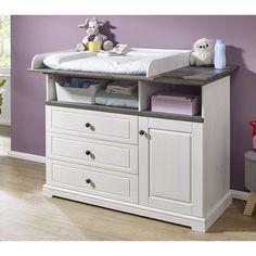 a baby crib with drawers and stuffed animals