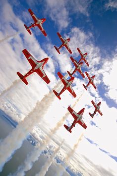 nine red and white airplanes flying in formation