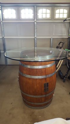 a wine barrel table with glass top in a garage