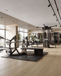 an empty gym with exercise equipment in the foreground and large windows to the side