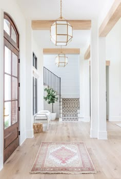 an entryway with wooden floors, white walls and wood trimming on the ceiling