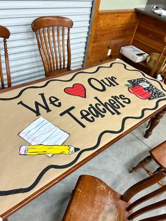 a table with chairs and a sign on it that says, we love our teachers