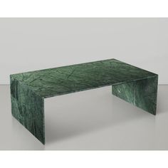 a green marble coffee table sitting on top of a white floor