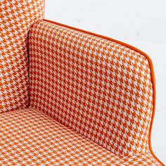 an orange and white checkered chair with the seat folded down to show the back