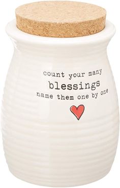 a white ceramic jar with a cork lid that says count your many blessings name them one by one