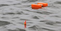 two orange buoys floating in the water next to each other