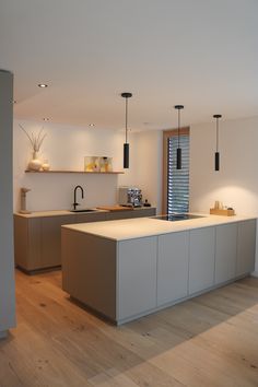 a modern kitchen with an island counter and wooden floors