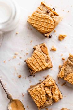 peanut butter chocolate chip cookie bars on a white surface with a spoon next to it