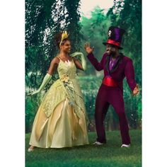 a man and woman dressed up as disney characters dancing in front of some trees on a sunny day