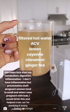 a woman holding a glass of tea in her hand with the caption, filtered hot water acv lemon cayenne cinnamon ginger tea