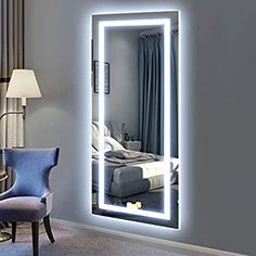 a bedroom with a chair and a large mirror on the wall