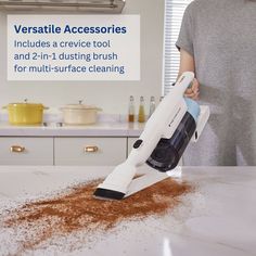 a person using a handheld vacuum to clean a kitchen counter top with brown stuff on it