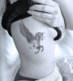 a woman is holding her stomach with a tattoo on it's side and the bottom half