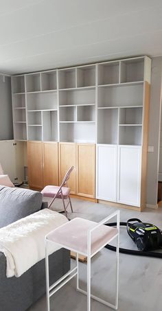 a living room filled with furniture and bookshelves next to a bed on top of a hard wood floor