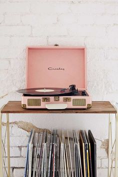 a record player sitting on top of a wooden table next to a bunch of records