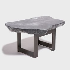 a stone table with metal legs on a white background in the shape of a rock