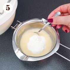 a woman is mixing batter in a bowl with a whisk on the side