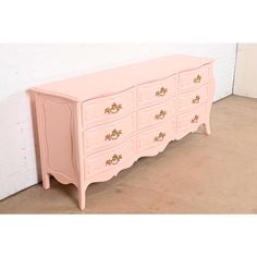 A gorgeous French Provincial Louis XV style nine-drawer triple dresser or credenza  By Baker Furniture   USA, Circa 1960s  Pink lacquered solid walnut, with original brass hardware.  Measures: 76"W x 19.75"D x 32.13"H.  Professionally refinished. Excellent condition. Pink Cabinet, Pink Painted Dresser, Pink Cabinets, Pink Dresser, French Provincial Dresser, French Provincial Furniture, Painted Dresser, Baker Furniture, French Provincial