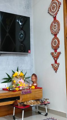 a living room with a flat screen tv on the wall and decorative artwork above it