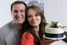 a man and woman holding a cake together